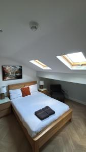 a bedroom with a large bed with two skylights at Hendham Rooms - Near Etihad Stadium, CoOp Live Arena, National Cycling Centre & 24 Hour Asda in Manchester +60 photos