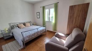 una camera da letto con un letto, un divano e una sedia di Apartment Marina a Supetar (San Pietro di Brazza)