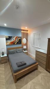 a bedroom with a bed with a painting on the wall at Hendham Rooms - Near Etihad Stadium, CoOp Live Arena, National Cycling Centre & 24 Hour Asda in Manchester