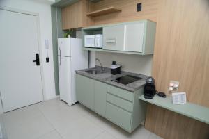a small kitchen with a sink and a refrigerator at Green One - Em Frente à Estação Luz com vaga rotativa in Sao Paulo