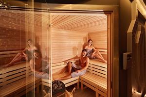 a group of people sitting in a sauna at Hotel Styl 70 in Pszczyna