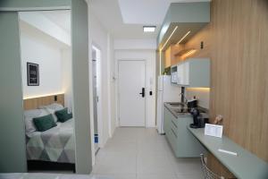 a kitchen with a sink and a bed in a room at Green One - Em Frente à Estação Luz com varanda e vaga rotativa in São Paulo