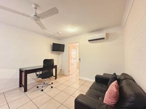 a living room with a couch and a desk at Unit 3 37 St Francis Dr Neat 1BR - AC & Parking in Moranbah +7 photos