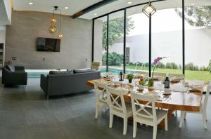 a dining room with a table and a couch at Casa Begonias Hotel mas Villas in Jiutepec