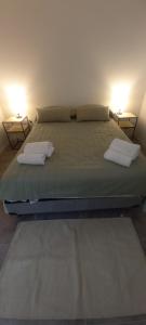 a bed with two pillows on it in a room at Trelew Cartref-Departamento Familiar Cerca del centro in Trelew