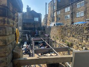 een groep mensen die aan tafels in een stenen muur zitten bij Sowerby Homes in Sowerby Bridge