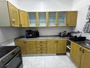 a kitchen with wooden cabinets and a sink at Stylish 2 Bedroom with 2 outside area in Abu Dhabi