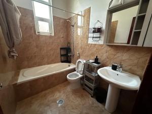 a bathroom with a sink and a toilet and a bath tub at Stylish 2 Bedroom with 2 outside area in Abu Dhabi