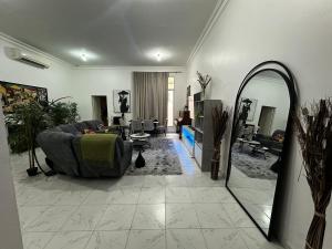 a living room with a couch and a mirror at Stylish 2 Bedroom with 2 outside area in Abu Dhabi +4 photos
