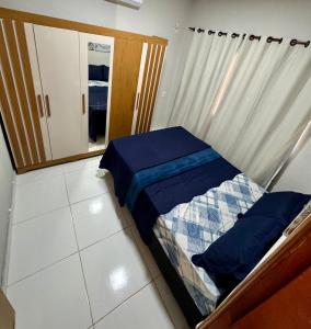 een kleine slaapkamer met een bed en een spiegel bij Brisa das dunas in Tutóia