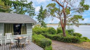 Cove Cottage by AvantStay Waterfront Views Spa في كوبيفيل: منزل على طاولة وكراسي على سطح السفينة