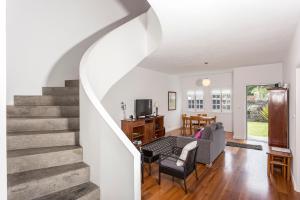 a living room with a staircase and a couch at Casa das Camélias - Family Villa by the lagoon in Sete Cidades
