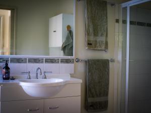 a bathroom with a white sink and a shower at Birdsland Suite in Belgrave Heights