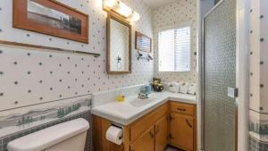 een badkamer met een wastafel, een toilet en een douche bij Lakefront Dock Hot Tub Swingset Deck Views Classic Lake House by AvantStay in Big Bear Lake +18 foto's