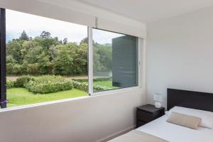 a bedroom with a large window with a view at Casa das Camélias - Family Villa by the lagoon in Sete Cidades