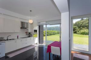 a kitchen with a table and a large window at Casa das Camélias - Family Villa by the lagoon in Sete Cidades