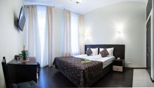 una camera d'albergo con letto e finestra di Guest House Roma a San Pietroburgo