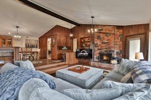 Bear Paw Cabin - 3 Living Areas, Hot Tub & Ping Pong Table في Mendon: غرفة معيشة مع أريكة ومدفأة