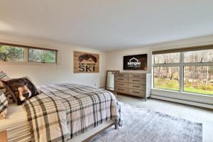 Bear Paw Cabin - 3 Living Areas, Hot Tub & Ping Pong Table في Mendon: غرفة نوم بسرير وخزانة ونوافذ