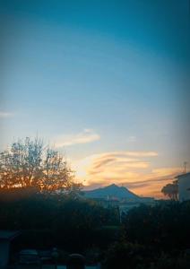 a sunset over a city with a mountain in the background at La grotta in Procida +2 photos