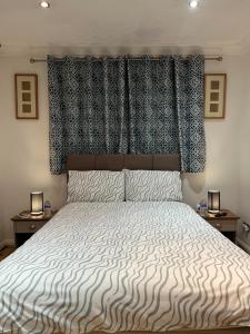a bedroom with a large bed with a large headboard at The Bungalow by SJP - Double Room in Northamtonshire