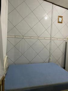 a bedroom with a bed with a tiled wall at Kitnet perto da praia Coroados in Guaratuba