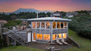 a large house with a lot of windows at Sanctuary by the Sea by AvantStay Waterfront Views in Arch Cape