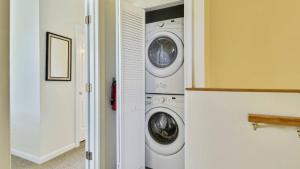 Coral Villa by AvantStay Close 2 DT Key West Shared Pool Patio في ستوك آيلاند: غرفة غسيل مع غسالتين ومجفف