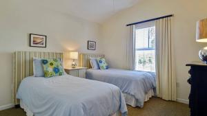 Coral Villa by AvantStay Close 2 DT Key West Shared Pool Patio في ستوك آيلاند: غرفة نوم بها سريرين ونافذة +24 صورة