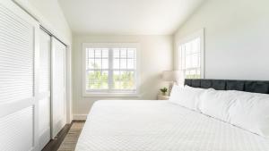 Paradise Point by AvantStay Golf Course Living في ستوك آيلاند: غرفة نوم بيضاء مع سرير ونافذتين +24 صورة
