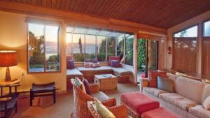 a living room with a couch and chairs and windows at Arch Cape Escape by AvantStay Sensational Clift Top Home w Pacific Ocean Views in Arch Cape