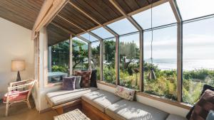 a living room with large windows and a couch at Arch Cape Escape by AvantStay Sensational Clift Top Home w Pacific Ocean Views in Arch Cape