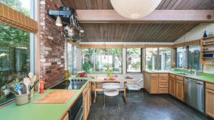 a kitchen with wooden cabinets and a table and chairs at Arch Cape Escape by AvantStay Sensational Clift Top Home w Pacific Ocean Views in Arch Cape +31 photos