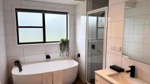 a bath tub in a bathroom with a window at Ocean Views on Lyrebird in Lakes Entrance +13 photos