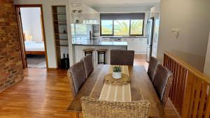 a kitchen and dining room with a table and chairs at Ocean Views on Lyrebird in Lakes Entrance
