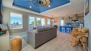 a living room with a couch and a kitchen at Private PoolHot Tub Near the Beach Gulf Glimpse Marlin Cove by AvantStay in Port Aransas