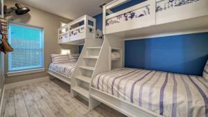 two bunk beds in a bedroom with blue walls at Private PoolHot Tub Near the Beach Gulf Glimpse Marlin Cove by AvantStay in Port Aransas +68 photos