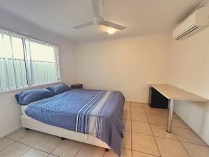 Un dormitorio con una cama y un escritorio. en Neat 1BR - AC & Parking, en Moranbah