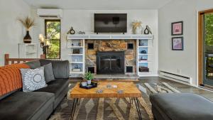 Lake It Right by AvantStay Lakefront w Dock Hot Tub Fire Pit Game Room في Long Pond: غرفة معيشة مع أريكة ومدفأة
