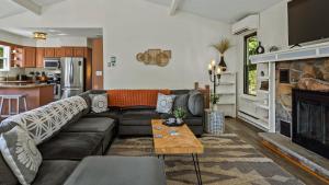 Lake It Right by AvantStay Lakefront w Dock Hot Tub Fire Pit Game Room في Long Pond: غرفة معيشة مع أريكة ومدفأة