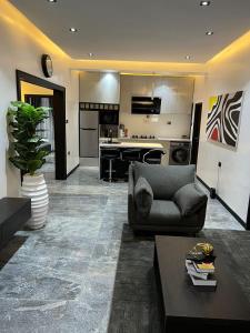 een woonkamer met een bank en een keuken bij bedandchuckle in Kaduna
