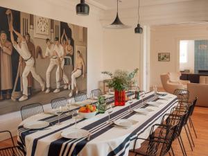 a long dining room with a long table with chairs at Maison Resaurie - Hôtel in Biarritz