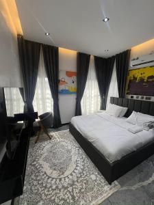 een slaapkamer met een bed en een bureau erin bij bedandchuckle in Kaduna