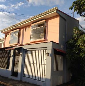 een roze en wit huis met een poort bij Casa #4 Studios in San Pedro