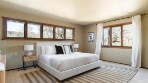 a bedroom with a white bed and windows at Gable by AvantStay Beautiful 3.5 Acre Oasis w Gorgeous Views Pool Hot Tub in Santa Rosa +29 photos