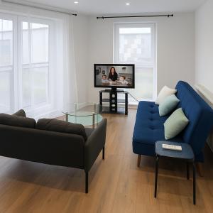 a living room with a blue couch and a tv at Morris lodge in Dartford