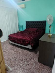 Un dormitorio con una cama con un edredón rojo. en Dpto de Licia, en Cipolletti 6 fotos más