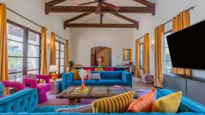 a living room with blue couches and a flat screen tv at Luxe 7BDR Oasis w Pool Putting Green Game Room Villa Del Gallo by AvantStay in Bermuda Dunes