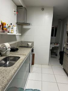 a white kitchen with a sink and a counter at In mare Bali Resort in Parnamirim