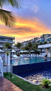 a pool with chairs and umbrellas at a resort at In mare Bali Resort in Parnamirim